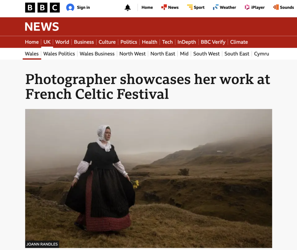 Joann Randles photograph of woman in traditional Welsh dress holding daffodils on misty Welsh hills